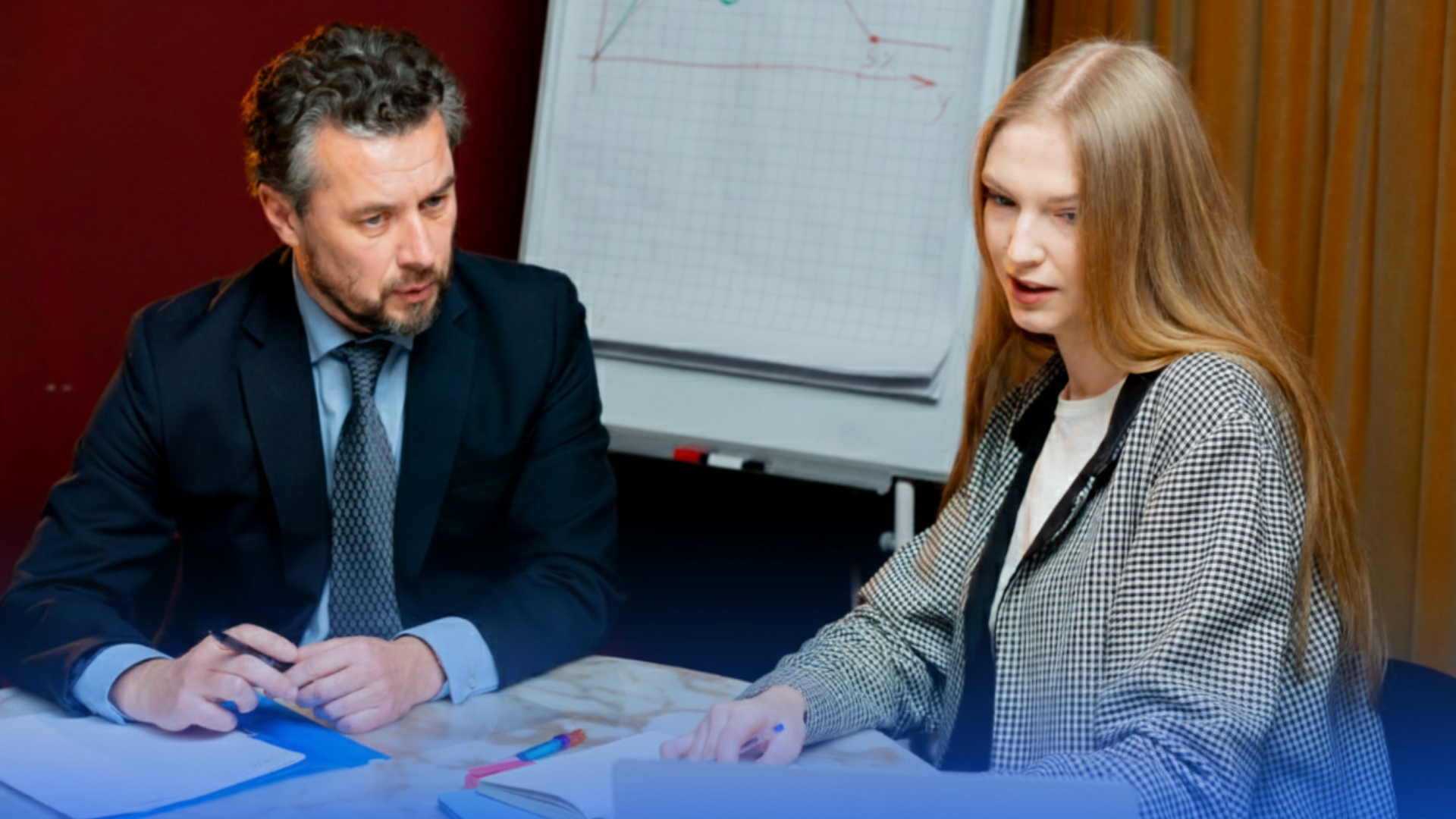 Dois executivos em reunião estratégica de Due Diligence analisando dados em um laptop e gráficos de performance, com sobreposição em tom azul profundo característica da identidade visual da VAAS.