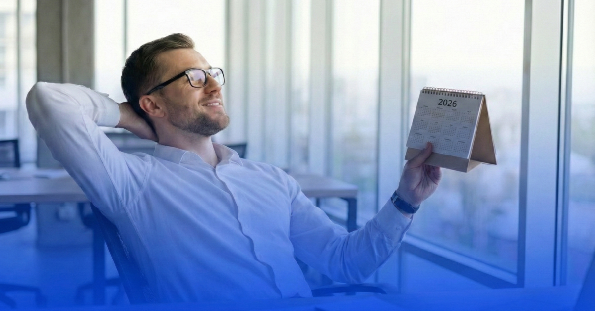 Homem sorridente em um escritório moderno, representando um Gestor de Riscos, sentado de forma relaxada com as mãos atrás da cabeça. Ele segura um calendário de mesa do ano de 2026, simbolizando o cumprimento antecipado do Calendário CVM 2026 e o controle sobre a Resolução CVM 47. A imagem possui um filtro azul degradê na base, alinhado à identidade visual da VAAS.
